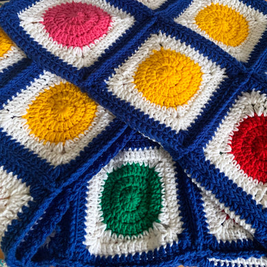 ThIs beautifully crafted handmade vintage crochet blanket throw features blue and white granny squares, each with a central dot of red, yellow, green, pink or blue. This super cozy throw is perfect for curling up in front of the fire with a good book or watching a movie.

In excellent condition.

Measures 42 x 65 inches