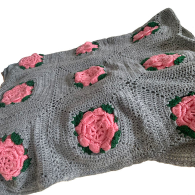 This beautifully crafted handmade vintage crochet blanket throw features gray granny squares, each with a central dimensional pink rose with green leaves. This super cozy throw is perfect for curling up in front of the fire with a good book or watching a movie.

In excellent condition.

Measures 60 x 68 inches