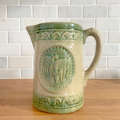 Antique grazing cows salt glazed yellow ware ceramic pitcher with decorative rim and base bands. Crafted by Medalta Stoneware, Canada, 1924. This utilitarian piece nicely complement any farmhouse or cottage kitchen!

In as found vintage condition, no chips/repairs, hairline crack near the spout (see photos), age-related wear to the exterior. Unmarked.

Measures 6 1/2 x 6 1/2 inches (incl. handle)
