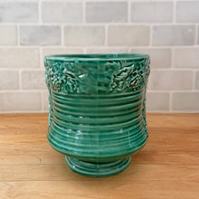 Load image into Gallery viewer, Vintage green glazed Bacchante oval planter jardiniere, shape 115, features embossed toga-clad figures with grapevine detail at the rim. Crafted by Sylvac, England, 1930s 1940s. A nice sized piece for your favourite bulbs and houseplants or use as decor.

In excellent condition, no chips/cracks/repairs.

Measures 9 1/4 x 5 3/4 x 5 1/2 inches

