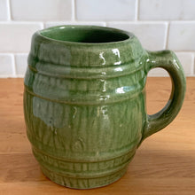 Load image into Gallery viewer, Vintage green barrel ceramic mugs and tankard pitcher set, includes six mugs and and one pitcher. Crafted by McCoy Pottery, USA, 1920s. Off the hop this set gives us all the beer, hot chocolate and cider vibes!

In excellent condition, no chips/cracks/repairs.

Mugs measure 3 3/4 x 4 5/8 inches. Capacity 18oz

Tankard Pitcher measures 5 1/4 x 8 inches. Capacity 72oz
