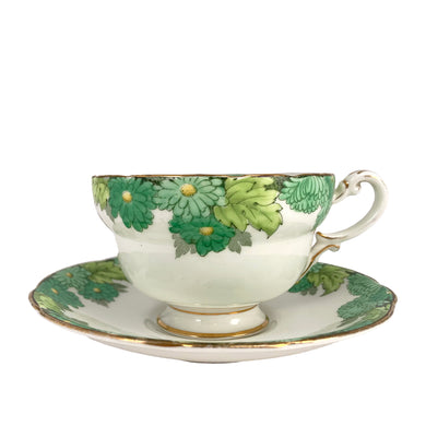 Vintage Chrysanthemum fine bone china teacup and saucer featuring flowers in shades of green and gold gilt trim. Crafted by Paragon, England, 1923-33. A lovely way to enjoy a cuppa tea!

In excellent condition, no chips, cracks or repairs. Maker's mark on the bottom.

Measures 4 x 2 3/8 inches | Saucer measures 5 1/2 inches