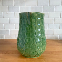 Load image into Gallery viewer, Vintage art deco gloss green ceramic yellow ware pitcher featuring climbing roses on a trellis pattern. Crafted by McCoy Pottery, USA, 1920s. A beautiful piece to add to your art pottery collection!

In excellent condition, no chips/cracks/repairs, age-related crazing. Typical manufacturing glaze pops. Unmarked.

Measures 5 1/4 x 8 3/4 inches
