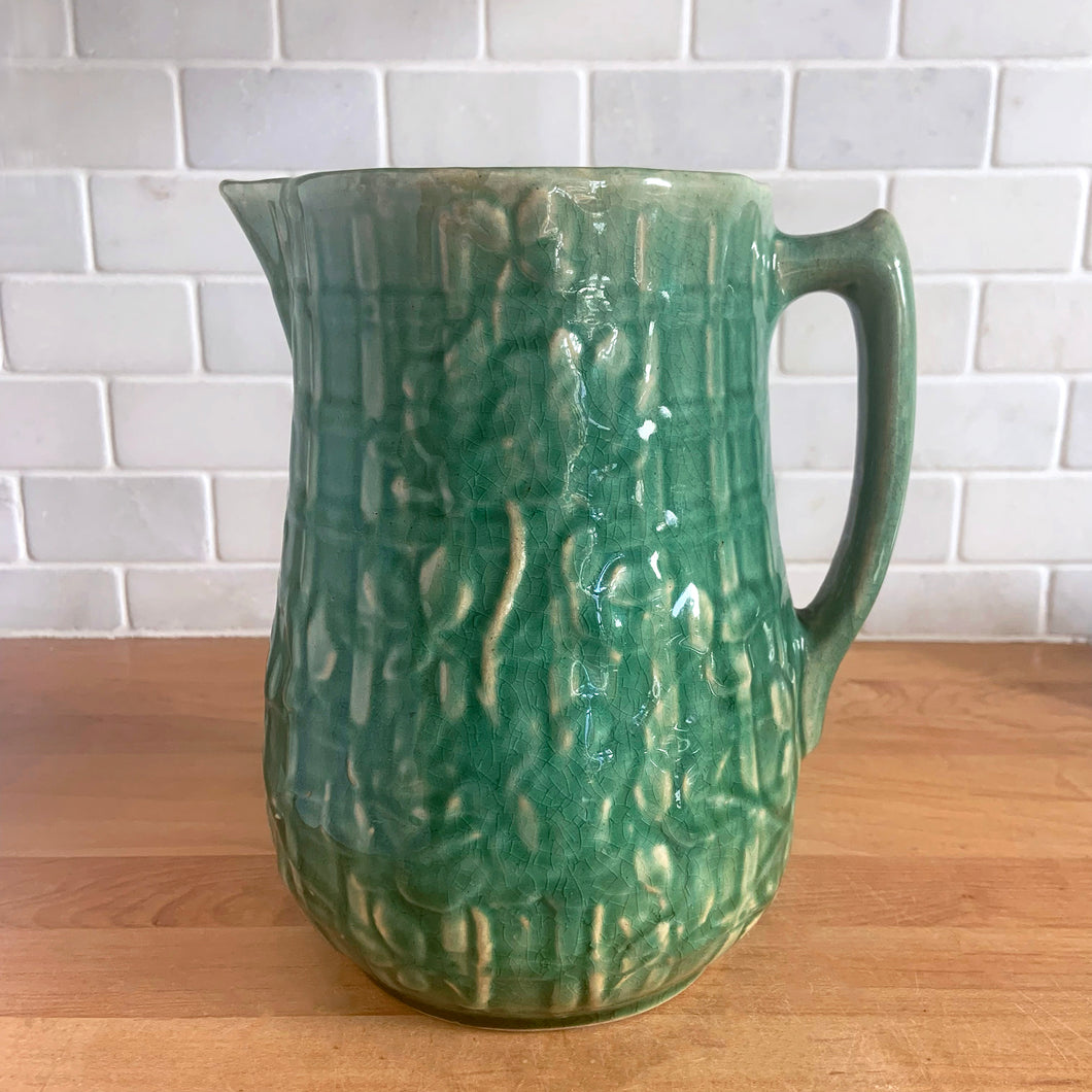 Vintage art deco gloss green ceramic yellow ware pitcher featuring climbing roses on a trellis pattern. Crafted by McCoy Pottery, USA, 1920s. A beautiful piece to add to your art pottery collection!

In excellent condition, no chips/cracks/repairs, age-related crazing. Typical manufacturing glaze pops. Unmarked.

Measures 5 1/4 x 8 3/4 inches