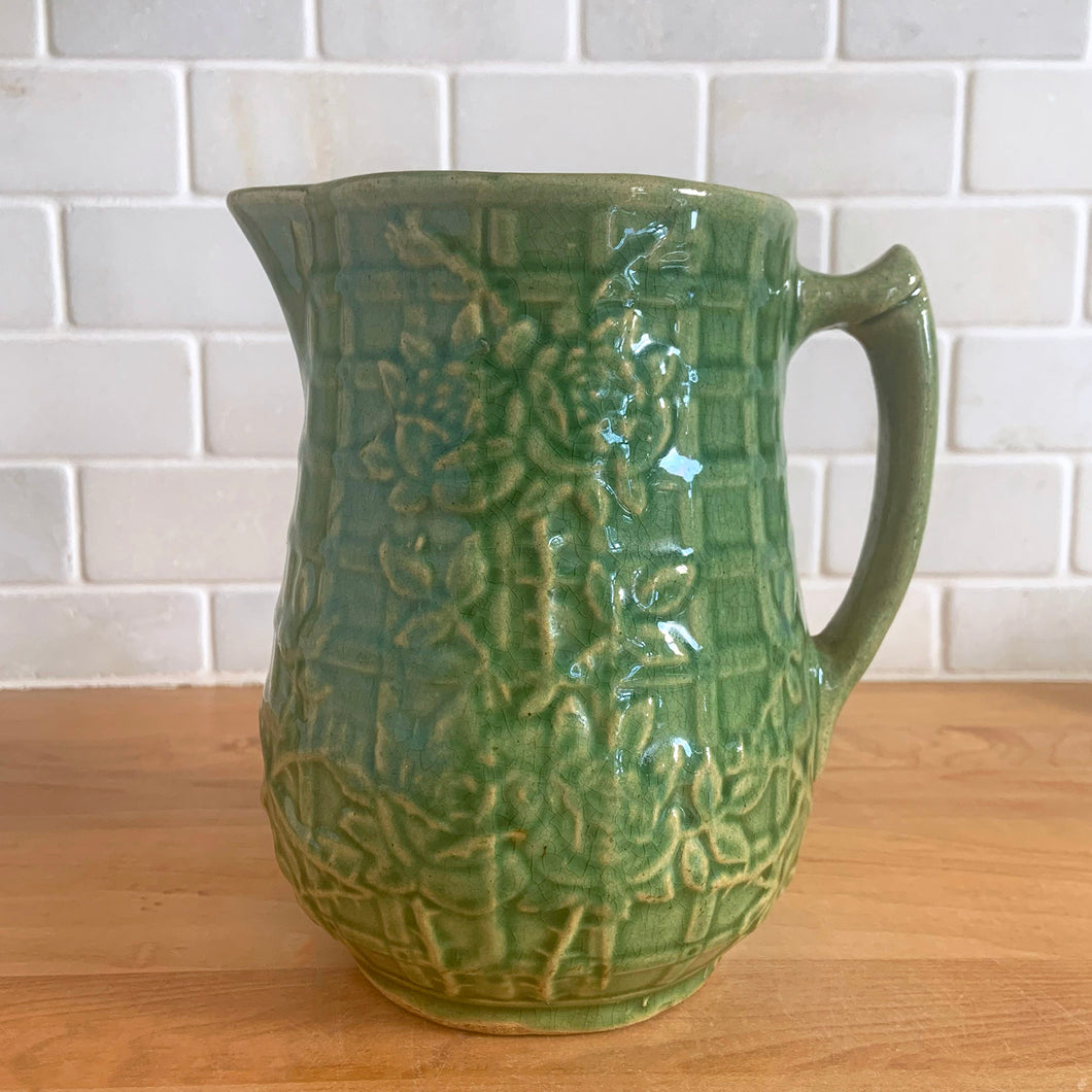 Vintage art deco gloss green ceramic pitcher featuring climbing roses on a trellis pattern. Crafted by McCoy Pottery, USA, 1930s. A beautiful piece to add to your art pottery collection and the perfect complement to any farmhouse, cottagecore, country, or shabby chic home decor!

In excellent condition, minor chip at the foot, no cracks/repairs, age-related crazing. Typical manufacturing glaze pops. Unmarked.

Measures 4 1/4 x 6 3/4 inches