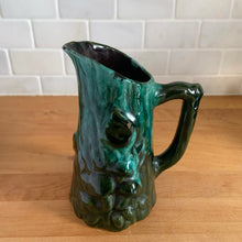 Load image into Gallery viewer, Vintage green drip glaze pitcher, featuring a woodland design of raised mushrooms and knots around a tree trunk. Crafted by Evangeline Pottery, Canada, 1960s. This sweet pitcher makes for a beautiful statement piece or a functional pitcher for your home.

In excellent condition, no chips/cracks/repairs.

Measures 5 x 3 5/8 x 6 1/4 inches
