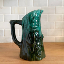 Load image into Gallery viewer, Vintage green drip glaze pitcher, featuring a woodland design of raised mushrooms and knots around a tree trunk. Crafted by Evangeline Pottery, Canada, 1960s. This sweet pitcher makes for a beautiful statement piece or a functional pitcher for your home.

In excellent condition, no chips/cracks/repairs.

Measures 5 x 3 5/8 x 6 1/4 inches

