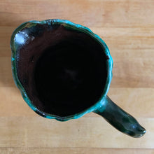 Load image into Gallery viewer, Vintage green drip glaze pitcher, featuring a woodland design of raised mushrooms and knots around a tree trunk. Crafted by Evangeline Pottery, Canada, 1960s. This sweet pitcher makes for a beautiful statement piece or a functional pitcher for your home.

In excellent condition, no chips/cracks/repairs.

Measures 5 x 3 5/8 x 6 1/4 inches
