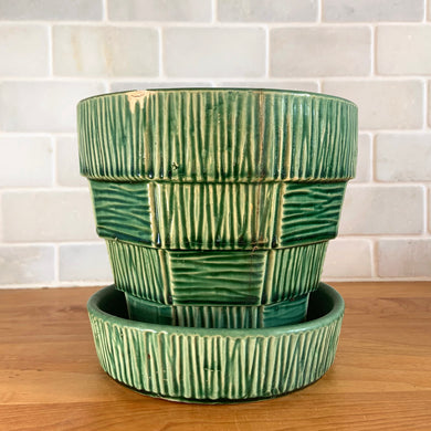 Striking vintage gloss green basketweave planter pot with attached saucer. Crafted by McCoy Pottery, 1953. This rare planter is must for any McCoy art pottery collector!

In as found vintage condition, chipped, two tight hairline cracks, hard water residue. Maker's mark on the bottom.

Measures 6 1/4 x 5 1/2 inches