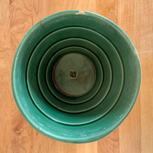 Load image into Gallery viewer, Striking vintage gloss green basketweave planter pot with attached saucer. Crafted by McCoy Pottery, 1953. This rare planter is must for any McCoy art pottery collector!

In as found vintage condition, chipped, two tight hairline cracks, hard water residue. Maker&#39;s mark on the bottom.

Measures 6 1/4 x 5 1/2 inches
