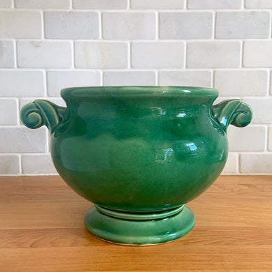 Highly collectible vintage mid-century green Art Deco round ceramic art pottery jardiniere planter with curled handles. Crafted by McCoy Pottery, USA, 1950s. The perfect home for your favourite houseplant or succulent!

In excellent vintage condition, no chips/cracks/repairs, age-related crazing. Maker's mark.

Measures 6 3/4 x 6 inches (10 1/4 inches from handle-to-handle)