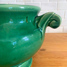 Load image into Gallery viewer, Highly collectible vintage mid-century green Art Deco round ceramic art pottery jardiniere planter with curled handles. Crafted by McCoy Pottery, USA, 1950s. The perfect home for your favourite houseplant or succulent!

In excellent vintage condition, no chips/cracks/repairs, age-related crazing. Maker&#39;s mark.

Measures 6 3/4 x 6 inches (10 1/4 inches from handle-to-handle)
