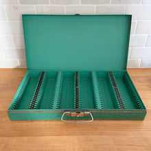 Load image into Gallery viewer, Vintage green metal storage box featuring slots for up to 150 photographic slide transparencies and handle. This is the perfect way to maintain the integrity of your family&#39;s vintage memories!  In good used vintage condition, scuffing commensurate with age. Hinges intact and lock mechanism in working condition.  Measures 14 1/2 x 7 5/8 x 2 1/8 inches   

