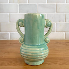 Load image into Gallery viewer, Rare vintage art deco Coronado Art Line pale green vase with double curled handles, 4A. Crafted by Brush McCoy Pottery, 1940s. This unique vase is a must-have for any art pottery collector. A lovely piece to use in your home decor or to give as a gift!

In excellent vintage condition, no chips/cracks/repairs. Marked on the bottom, A4 USA.

Measures 3 1/2 x 4 5/8 inches (incl. handles)
