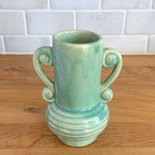 Load image into Gallery viewer, Rare vintage art deco Coronado Art Line pale green vase with double curled handles, 4A. Crafted by Brush McCoy Pottery, 1940s. This unique vase is a must-have for any art pottery collector. A lovely piece to use in your home decor or to give as a gift!

In excellent vintage condition, no chips/cracks/repairs. Marked on the bottom, A4 USA.

Measures 3 1/2 x 4 5/8 inches (incl. handles)
