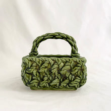 Load image into Gallery viewer, Adorable vintage mid-century dark green handled basket planter with a criss cross rope pattern and twisted rope design handle. Produced by Inarco, Japan, circa 1950s. A sweet basket for a few succulents, use a decor piece or candy dish.  In as found vintage condition, free from cracks/repairs, minor glaze chipping (see photos). Marked on the bottom. Original sticker.  Measures 5 3/4 x 4 1/4 x 3 3/4
