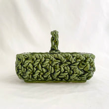 Load image into Gallery viewer, Adorable vintage mid-century dark green handled basket planter with a criss cross rope pattern and twisted rope design handle. Produced by Inarco, Japan, circa 1950s. A sweet basket for a few succulents, use a decor piece or candy dish.  In as found vintage condition, free from cracks/repairs, minor glaze chipping (see photos). Marked on the bottom. Original sticker.  Measures 5 3/4 x 4 1/4 x 3 3/4
