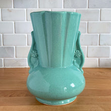 Load image into Gallery viewer, Vintage Art Deco green speckle glazed ceramic flower vase featuring a round base and a ribbed panel design flanked by two handles highlighted with a flower motif. Crafted by York Pottery (precursor to Pfaltzgraff), USA, circa 1930s. A beautiful piece to add to any art pottery collection! Excellent condition. Marked with impressed keystone, York P 288 USA. Measures 5 x 8 inches
