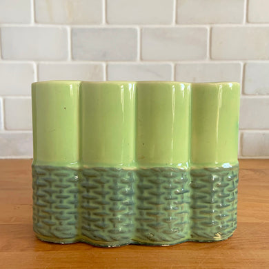 Vintage mid-century two-tone green basketweave art pottery planter. Crafted by McCoy Pottery, USA, circa 1950s. A collectible art pottery planter that is perfect for forcing spring flower bulbs, planting succulent or a floral arrangement.

In excellent condition, no chips/cracks/repairs. Maker's mark.

Measures 5 5/8 x 2 1/2 x 4 1/4 inches