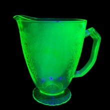 Load image into Gallery viewer, Vintage Florentine 1 green uranium depression era glass 36oz pitcher features a scalloped foot and glows beautifully under black light. Crafted by Hazel-Atlas Glass, USA, 1932 - 1935. Perfect for adding a touch of sophistication to any table setting or display in your uranium glass collection!

In excellent used vintage condition, no chips, minor wear.

Measures 7 x 4 7/8 x 6 3/4 inches (incl. handle/spout)
