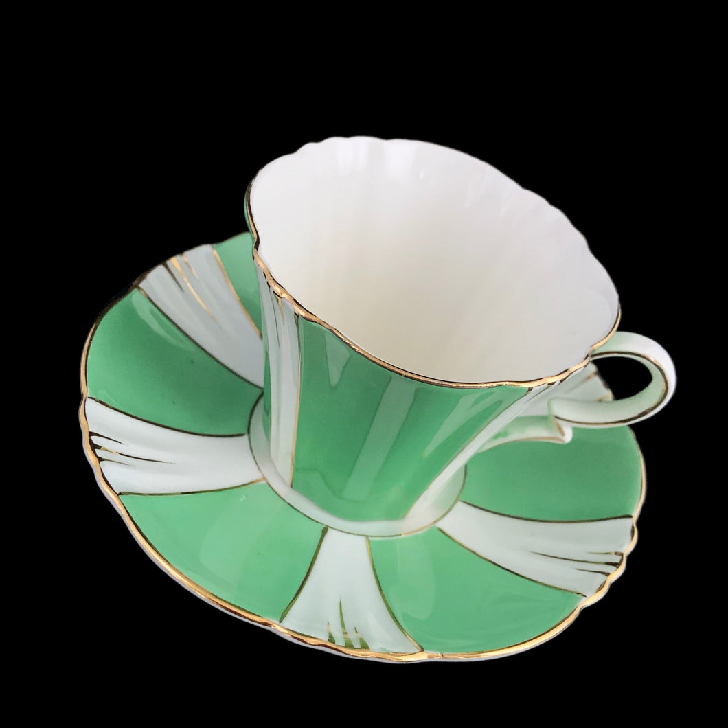 This antique art deco style white bone china teacup and saucer is simply elegant! Both the cup and saucer have a lovely square scalloped edge, hand painted in green colour blocks alternating with white along with gold gilt details and rim. Crafted by Royal Albert Crown China, England, between 1925 to 1927. A beautiful old piece that has stood the test of time!