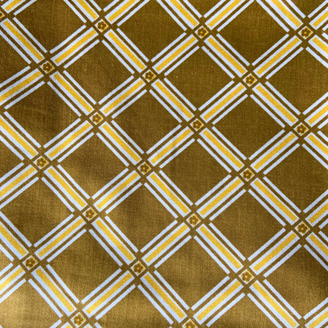 Vintage geometric tartan patterned fabric remnant with flower detail in olive green and yellow and white. Crafted by 5th Avenue Design, USA. Label states Copyright - USA 5th Avenue Design Inc. Vat Dyes - preshrunk Permanent Schreinered Protected With COVGARD - Screen Printed. Perfect for home decor crafting!

In excellent condition, no stains/tears.

Measures 24 1/2 x 108 inches / 3 yards