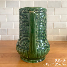 Load image into Gallery viewer, Antique vintage art deco gloss green Rosella 320 ceramic yellow ware pitcher featuring climbing roses on a basketweave pattern. Crafted by Robinson Clay Product Company, the precursor to Robinson Ransbottom Pottery, USA, early 1900s. A beautiful piece to add to your art pottery collection! Option 5, 6 1/2 x 7 1/2 inches
In as found vintage condition, no cracks/repairs, chips to handle, age-related crazing and large manufacturing glaze pops. Maker&#39;s marks.
