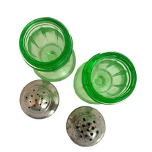 Load image into Gallery viewer, Pair of antique vintage depression era art deco uranium glass Ribbon footed salt and pepper shakers with metal lids. Crafted by Hazel-Atlas Glass, USA, 1930 - 1935. This timeless kitchen accessory and their novel green uranium glass, which glows brilliantly under black light, adds a unique accent to your kitchen and table decor!

In good vintage condition, no chips, one shaker has a horizontal scratch. Age appropriate wear to the lids.

Measures 1 1/2 x 3 3/4 inches
