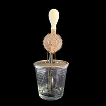 Load image into Gallery viewer, Vintage A&amp;J clear depression era glass 1 pint (2 cup) hand beater mixer with white wood handle. The glass cup has measuring lines in 1/2 cup increments up to the 1 cup line and 1/4 cup increments up to the 2 cup line and the reverse in 2 ounce increments. Crafted by Hazel-Atlas Glass, circa 1920s. Perfect for beating eggs or mixing salad dressings.

In as found vintage condition, with wear.
