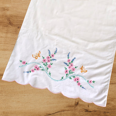 A lovely pair of vintage white cotton pillowcases, featuring hand embroidered pink, blue flowers with green leaves, a path of turquoise and two golden butterflies, plus a finished scalloped edge in pink. A gorgeous addition to your bed linens! In good vintage condition. Measures 31 x 18 1/2 inches