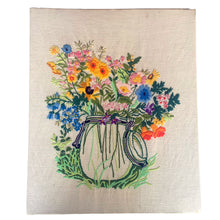 Load image into Gallery viewer, Vintage hand stitched colourful crewel of flowers in a mason jar in shades of orange, yellow, pink, blue and green on natural linen. This piece is. Written on the back, Made by Sharon Rife, January/80". A lovely piece of stitched art to enhance your home decor.

The crewel is in good vintage condition. In need of re-blocking and framing.

Measures 16 x 20 inches

