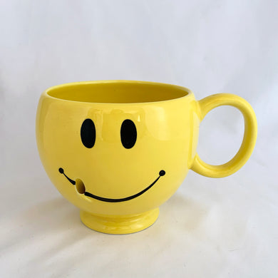 Bring on the happy with this vintage smiley face mug. Produced by Teleflora Gift, China. This one is a bit unusual as it has a spot to insert a stick into the smile, to hold balloons or a small sign perhaps.  In excellent condition, free from chips/cracks/repairs. Looks like it's barely been used.  Measures 4 1/4 x 4 1/8 inches  Capacity 20 ounces