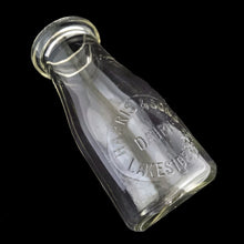 Load image into Gallery viewer, Angled view of Vintage Harris &amp; Sons Dairy Lakeside 2392 8 oz Clear Glass Cream Bottle showing embossed label. Made by Dominion Glass, Canada, 1950s.
