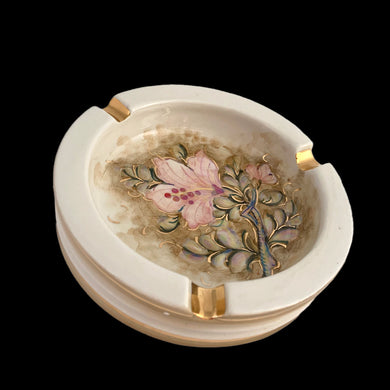 Vintage ceramic ashtray featuring hand painted pink hibiscus flower and green leaves on an cream ground with gold details. Crafted by Torretti Deruta, Italy, 1960s. A beautiful decorative ceramic ashtray!  In vintage condition, minor chip, see photos, otherwise excellent.  Measures 5 1/2 x 1 3/4 inches