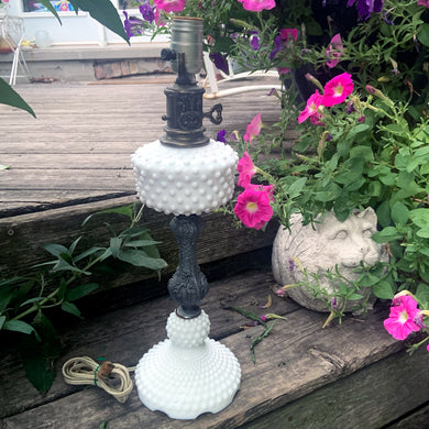 Lovely vintage white hobnail milk glass table lamp with decorative brass fittings. Perfect for a bedside table and hall table and will complement many decor styles.

In excellent condition, no chips and in good working order.

Measures 5 1/4 x 17 5/8 inches to the top of the socket