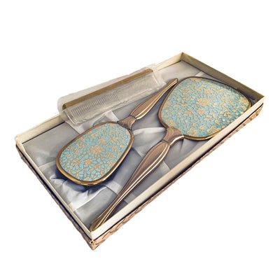Vintage Hollywood Regency 3-piece gold-toned vanity grooming set featuring turquoise and gold lace floral backing on the mirror and hairbrush with a clear/gold plastic comb. A beautiful set! Each piece is in like-new condition, in original box.