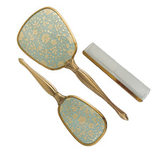 Load image into Gallery viewer, Vintage Hollywood Regency 3-piece gold-toned vanity grooming set featuring turquoise and gold lace floral backing on the mirror and hairbrush with a clear/gold plastic comb. A beautiful set! Each piece is in like-new condition, in original box.
