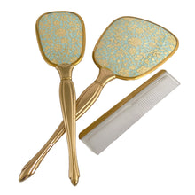 Load image into Gallery viewer, Vintage Hollywood Regency 3-piece gold-toned vanity grooming set featuring turquoise and gold lace floral backing on the mirror and hairbrush with a clear/gold plastic comb. A beautiful set! Each piece is in like-new condition, in original box.
