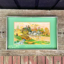 Load image into Gallery viewer, Stunning vintage reverse painted foil art pewter framed handled tray featuring a country landscape, with gold carriage coach, white horses and passengers. The handles show Rene Macintosh style rosettes. Crafted by Rusch, Germany, 1920s. Perfect as a vanity tray, to serves drinks and snacks or even wall art.

The painting is in excellent condition with minor age-related wear.

Measures 17 3/8 x 11 1/2 (19 5/8 with handles)
