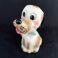 Load image into Gallery viewer, Show off the playful charm of this adorably freckle faced ceramic hound dog figurine! Its wide-eyed expression and pink tongue will add a dash of fun to any room. This beige, tan and black canine features a classic blue bow tie and is sure to charm everyone who sees it!  In excellent condition, free form chips/cracks/repairs. Marked &quot;Japan&quot; on the bottom.  Measures 2 x 4 1/2 inches
