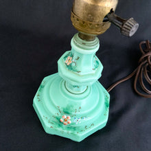 Load image into Gallery viewer, This uniquely shaped and rare vintage depression era art deco style green uranium slag glass boudoir table lamp features an octagonal base with hand painted enamel flowers in shades of pink, blue, green and brown. Created and crafted by Houze Art Glass in the USA, circa 1930. The best part is that lovely lamp glows brilliantly under black light. The lamp base with socket measures 3 7/8 x 7 inches. Original cord.
