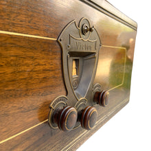 Load image into Gallery viewer, Angled close-up of Victor radio faceplate, tuning window and wooden control knobs with gold trim

