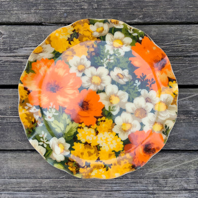 This retro FAB serving tray screams SPRING with its vibrant orange, yellow, white and green florals. This gorgeous decorator fabric was pressed between 2 layers of a plastic material and molded into a tray with a sweet ruffled edge. Produced by Hardy Glenwood in Canada, circa 1960s/70s. A great addition to your spring and summer entertaining! In excellent condition. Measures 13 1/4 inches