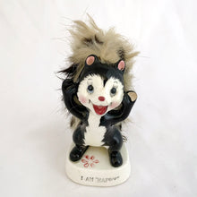 Load image into Gallery viewer, A vintage-style dancing skunk figurine on a white base that reads 'I AM HAPPY'. The skunk is black and white with pink inner ears, a red nose and mouth, and fluffy beige-gray hair

