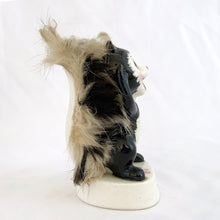 Load image into Gallery viewer, Left profile view of 1950s Napco Originals hand-painted porcelain skunk figurine holding a fabric flower, real fur tail visible, on cream triangular base
