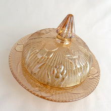 Load image into Gallery viewer, This vintage &quot;Iris Iridescent&quot; pressed marigold carnival glass covered butter dish features an intricately detailed dome with iris flowers featured on a herringbone pattern plus ribbed conical finial. It makes a lovely addition to any tablescape.  In as found vintage condition, 2 rim chips on the dish and 1 chip on the rim of the dome. Price reflect condition.  Measures 5 3/4 x 4 3/8 inches
