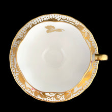 Load image into Gallery viewer, A gorgeous white bone china teacup and saucer featuring gold gilt ivy leaves and trim with pink berries florals. Crafted by Royal Chelsea, England, 1940s. A lovely addition to any china collection!

In excellent vintage condition, no chips, cracks or repairs.

Teacup measures 3 1/2 x 2 5/8 inches

Saucer measures 5 1/2 inches
