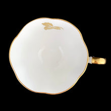 Load image into Gallery viewer, A gorgeous white bone china teacup and saucer featuring gold gilt ivy leaves and trim with pink berries florals. Crafted by Royal Chelsea, England, 1940s. A lovely addition to any china collection!

In excellent vintage condition, no chips, cracks or repairs.

Teacup measures 3 1/2 x 2 5/8 inches

Saucer measures 5 1/2 inches
