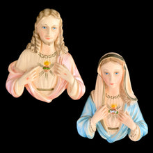 Load image into Gallery viewer, Front view of matched pair of 1950s hand-painted chalkware wall plaques: Sacred Heart of Jesus in pink robes with flaming heart, and Immaculate Heart of Mary in blue veil and robes, both with blue eyes and gold-tone necklace detail, Michigan Artistic Creations USA Model 790

