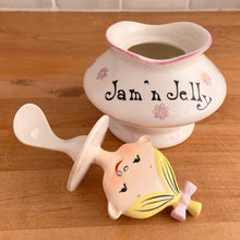 Load image into Gallery viewer, Rare vintage mid-century era Jolly Girls ceramic Jam&#39;n Jelly jar with spoon. Holt Howard, Japan, imported by LIpper and Mann, 1950s. Add this adorable kitschy piece to your collection!

In very good vintage condition, no chips/cracks/repairs, minor discolouration on the underside of the lid where the ceramic stilt pin was placed during firing. Marked Japan.

Measures 3 3/4 x 3 3/4 x 5 1/4 inches
